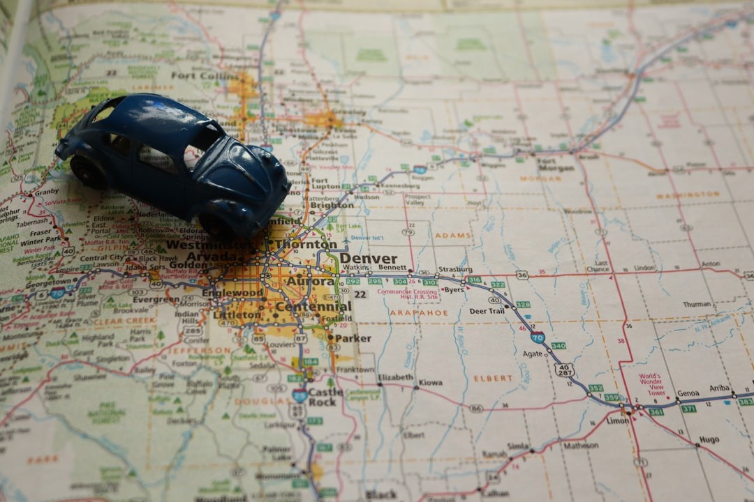 A toy blue car on a roadmap of the Denver, Colorado area.